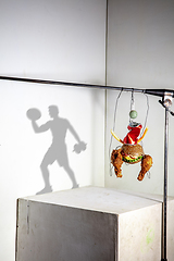 Image showing Flying food composition making beautiful sportsman drawing shadow on the wall
