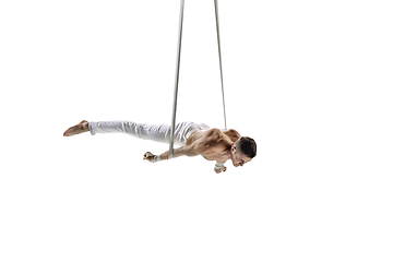 Image showing Young male acrobat, circus athlete isolated on white studio background. Training perfect balanced in flight