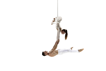 Image showing Couple of young acrobats, circus athletes isolated on white studio background. Training perfect balanced in flight