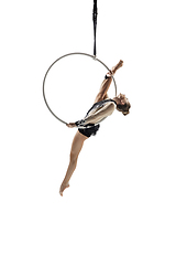 Image showing Young female acrobat, circus athlete isolated on white studio background. Training perfect balanced in flight