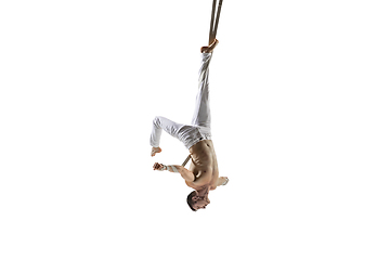 Image showing Young male acrobat, circus athlete isolated on white studio background. Training perfect balanced in flight