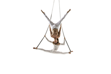 Image showing Couple of young acrobats, circus athletes isolated on white studio background. Training perfect balanced in flight