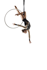 Image showing Young female acrobat, circus athlete isolated on white studio background. Training perfect balanced in flight