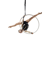 Image showing Young female acrobat, circus athlete isolated on white studio background. Training perfect balanced in flight