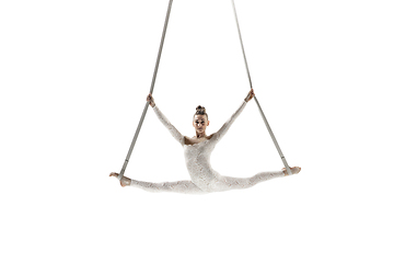 Image showing Young female acrobat, circus athlete isolated on white studio background. Training perfect balanced in flight