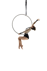 Image showing Young female acrobat, circus athlete isolated on white studio background. Training perfect balanced in flight