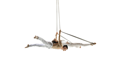 Image showing Couple of young acrobats, circus athletes isolated on white studio background. Training perfect balanced in flight