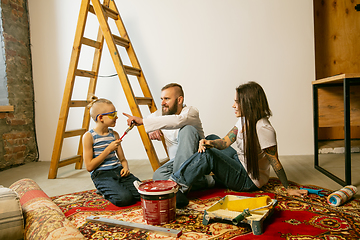 Image showing Young family doing apartment repair together themselves. Mother, father and son doing home makeover or renovation