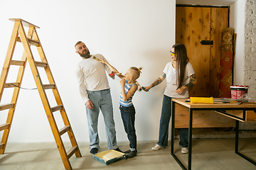 Image showing Young family doing apartment repair together themselves. Mother, father and son doing home makeover or renovation