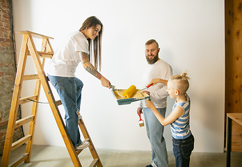 Image showing Young family doing apartment repair together themselves. Mother, father and son doing home makeover or renovation