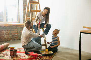 Image showing Young family doing apartment repair together themselves. Mother, father and son doing home makeover or renovation