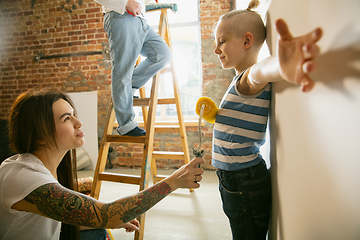 Image showing Young family doing apartment repair together themselves. Mother, father and son doing home makeover or renovation