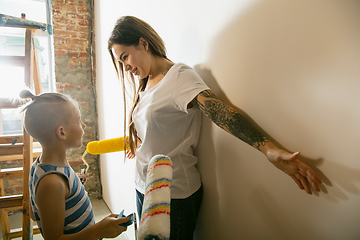 Image showing Young family doing apartment repair together themselves. Happy mother and son doing home makeover or renovation