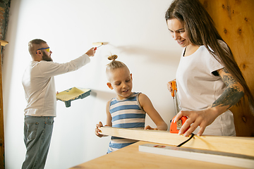 Image showing Young family doing apartment repair together themselves. Mother, father and son doing home makeover or renovation