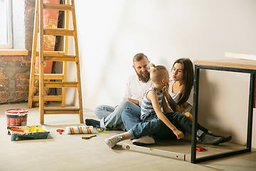 Image showing Young family doing apartment repair together themselves. Mother, father and son doing home makeover or renovation