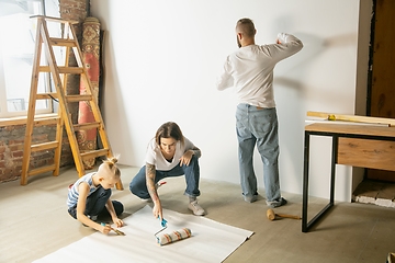 Image showing Young family doing apartment repair together themselves. Mother, father and son doing home makeover or renovation