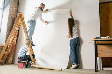 Image showing Young family doing apartment repair together themselves. Mother, father and son doing home makeover or renovation