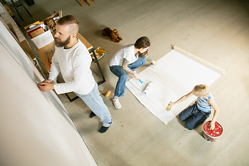 Image showing Young family doing apartment repair together themselves. Mother, father and son doing home makeover or renovation