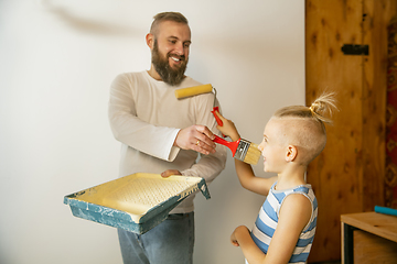 Image showing Young family doing apartment repair together themselves. Happy father and son doing home makeover or renovation