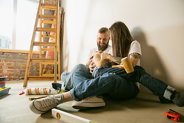 Image showing Young family doing apartment repair together themselves. Mother, father and son doing home makeover or renovation