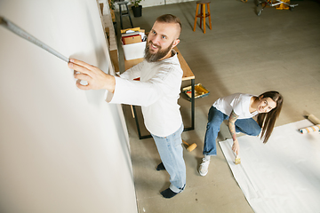 Image showing Young family doing apartment repair together themselves. Married man and woman doing home makeover or renovation