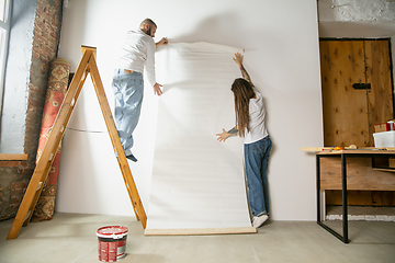 Image showing Young family doing apartment repair together themselves. Married man and woman doing home makeover or renovation