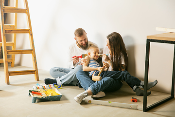 Image showing Young family doing apartment repair together themselves. Mother, father and son doing home makeover or renovation