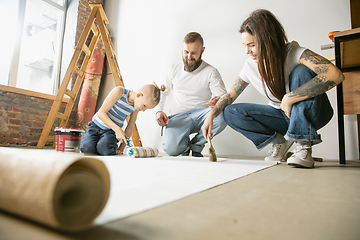 Image showing Young family doing apartment repair together themselves. Mother, father and son doing home makeover or renovation