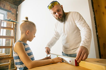 Image showing Young family doing apartment repair together themselves. Happy father and son doing home makeover or renovation