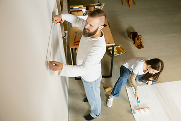 Image showing Young family doing apartment repair together themselves. Married man and woman doing home makeover or renovation