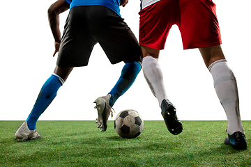 Image showing Close up legs of professional soccer, football players fighting for ball on field isolated on white background