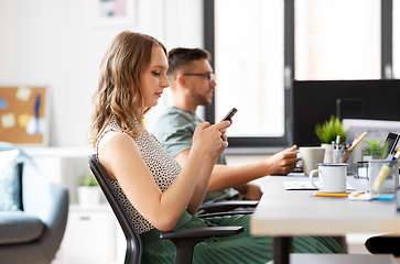 Image showing businesswoman using smartphone at office