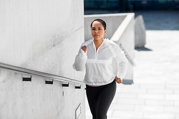 Image showing african american woman running upstairs outdoors