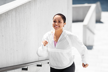 Image showing african american woman running upstairs outdoors