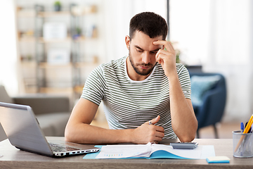 Image showing man with files and calculator works at home office