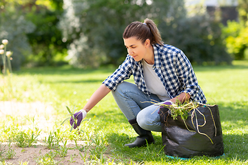 Image showing woman weeding flowerbed at summer garden