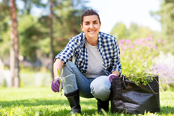 Image showing woman weeding flowerbed at summer garden