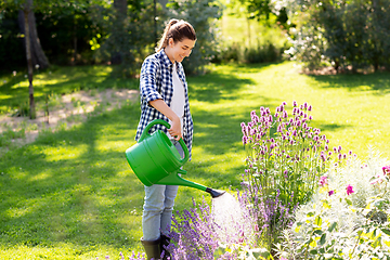 Image showing young woman watering flowers at garden