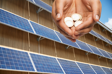 Image showing hands holding money over solar panels