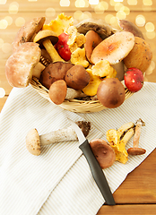 Image showing basket of different edible mushrooms and knife