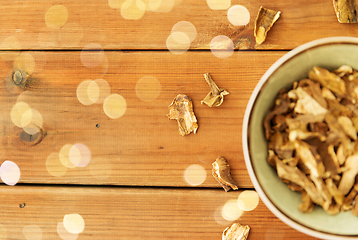 Image showing dried mushrooms in bowl on wooden background