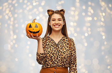 Image showing woman in halloween costume of leopard with pumpkin