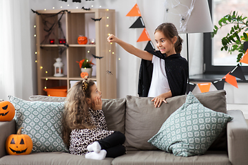 Image showing girls in halloween costumes playing with spider