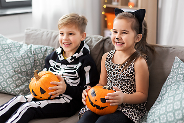 Image showing kids in halloween costumes with pumpkins at home