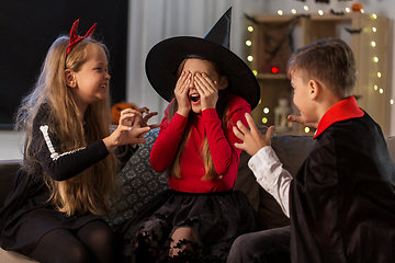 Image showing kids in halloween costumes playing at home