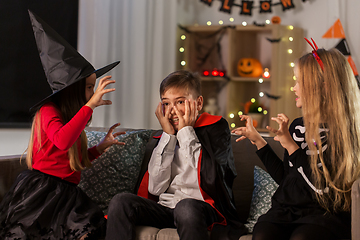 Image showing kids in halloween costumes playing at home