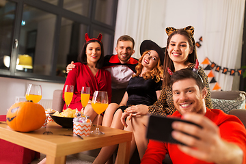 Image showing happy friends in halloween costumes taking selfie