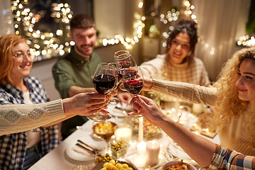 Image showing happy friends drinking red wine at christmas party