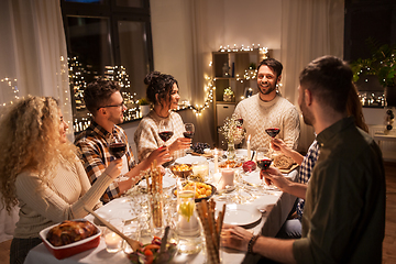 Image showing happy friends drinking red wine at christmas party