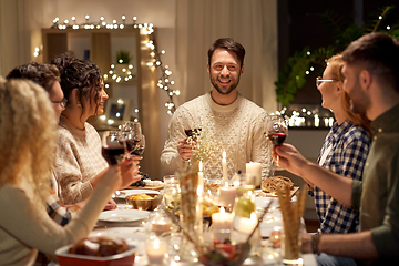 Image showing happy friends drinking red wine at christmas party